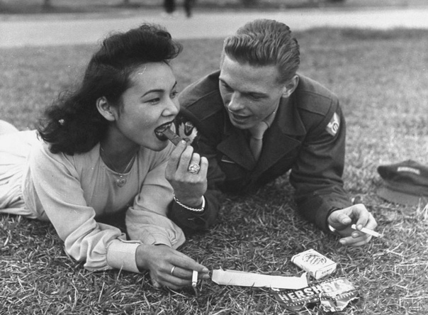 Фото, Япония, вторая половина 1940-х годов. Японская девушка и американский солдат едят шоколад и курят