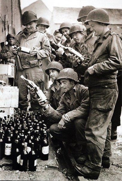 Американские солдаты из 4й пехотной дивизии с трофейным алкоголем, оставленным отступающими немецкими войсками (ШербурОктевиль, Франция, 5 июля 1944 года